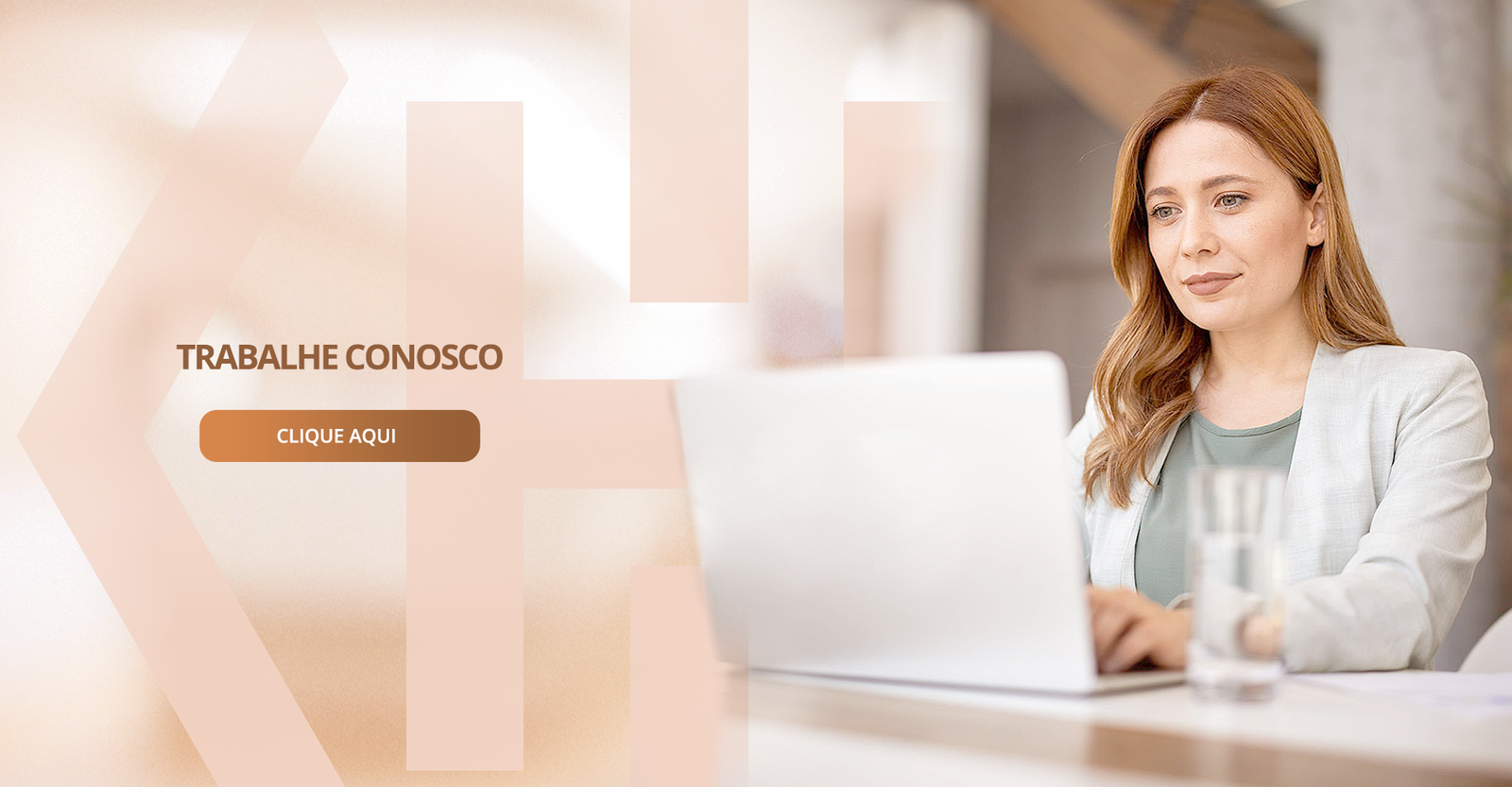 Uma mulher está sentada à mesa usando um laptop.